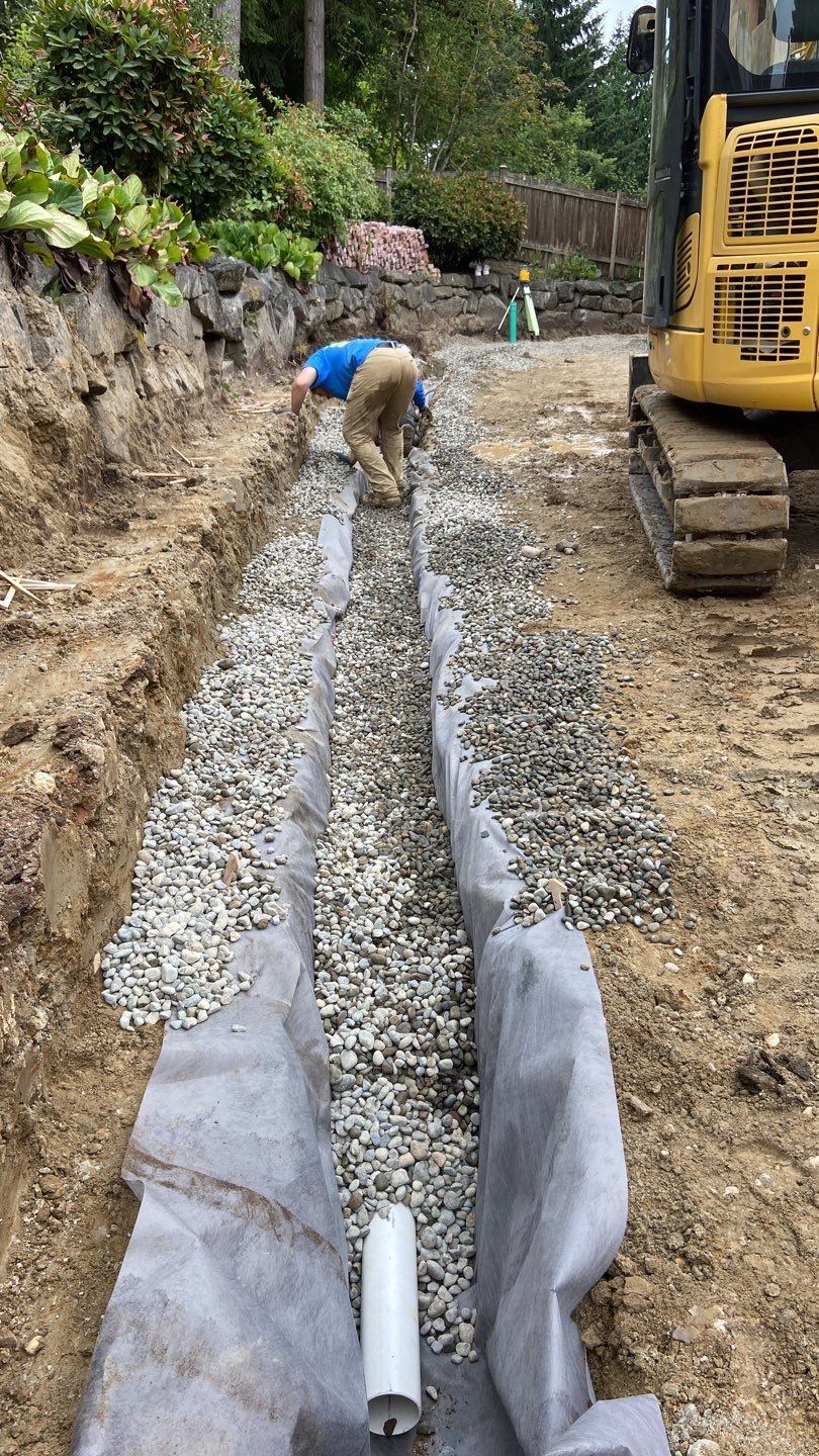 Bedding a pipe in gravel for drainage and protection.