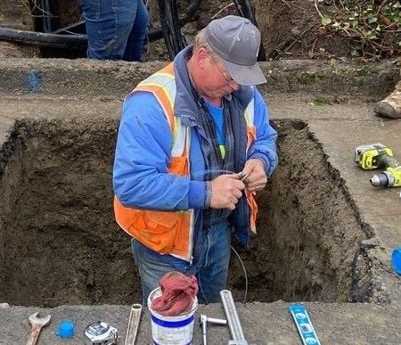 Stan, one of our foreman, is an extremely talented pipelayer. Here, he is shown preparing to tap into the main waterline for a new connection.